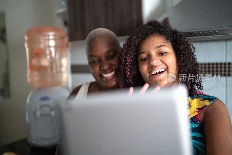 母亲和女儿在家里使用数字平板电脑进行视频通话/视频博客